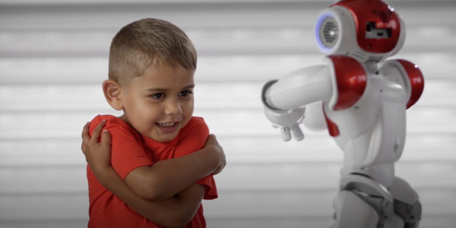 Little boy engaging with a small robot