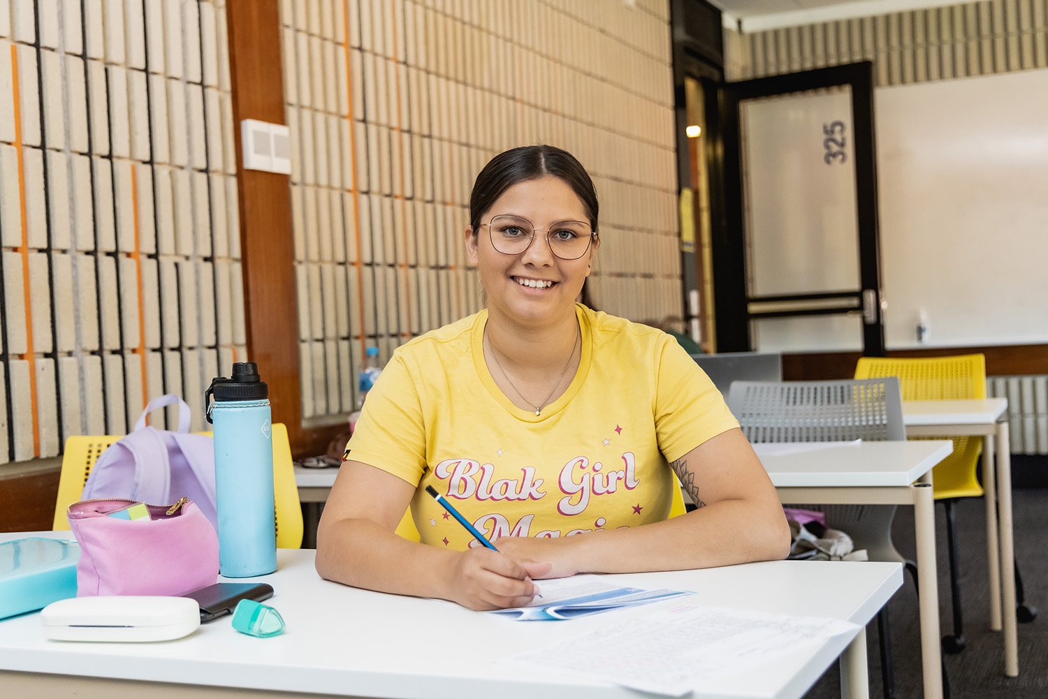 An Indigenous student doing work on a desk