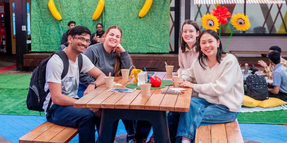 Four people sitting around a picnic table.