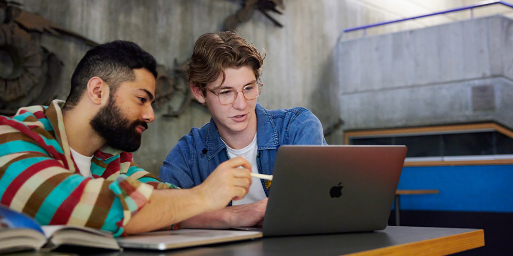 Two people looking at a laptop.