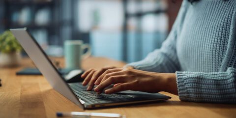 A woman typing on a laptop