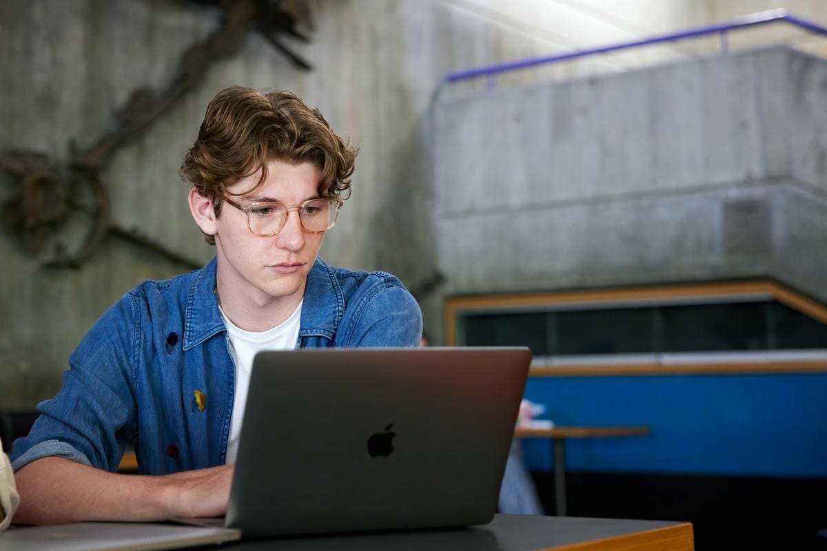 Student looking concentrated, looking at a laptop