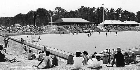 Students playing hocky on an oval