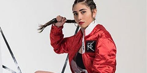 Antoinette Raphael wearing an red bomber jacket that she designed for her fashion brand RAW WAR