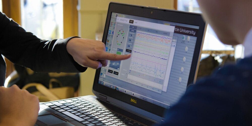 Two students analysing consumer research data on a laptop