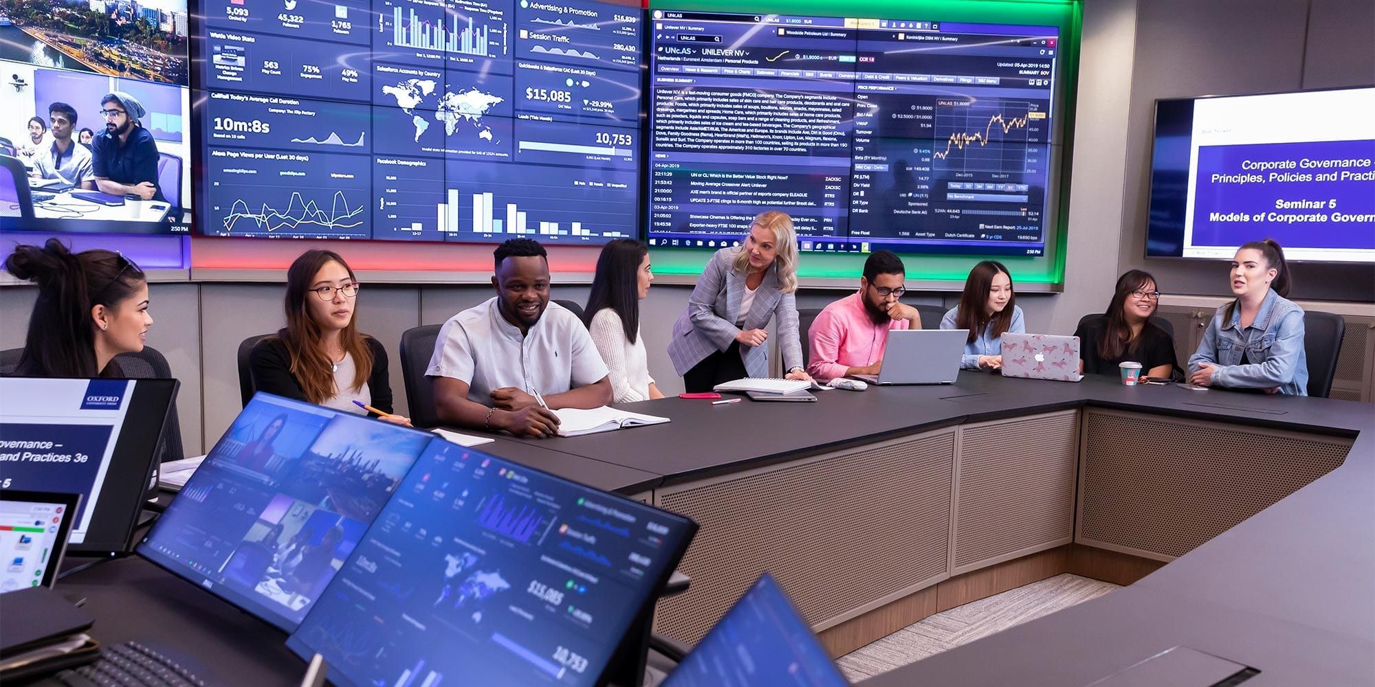 Students sitting in management HQ infront of a wall of screens