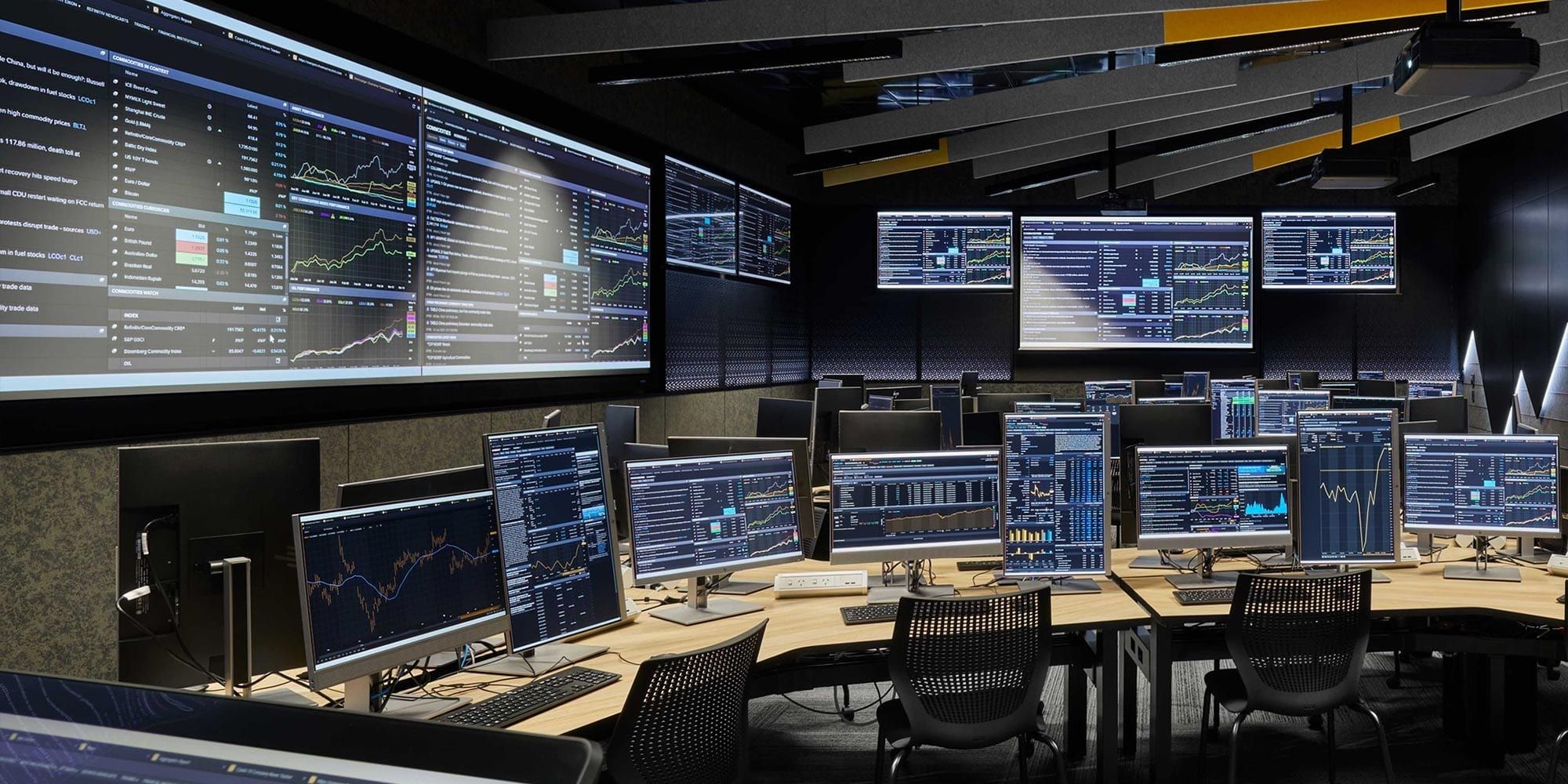 Row of desks inside the trading room facing main screens