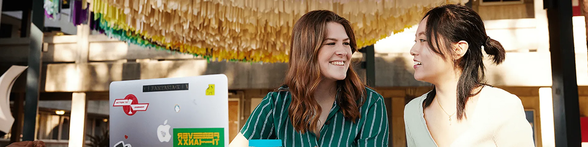 Smiling students and a laptop - play video