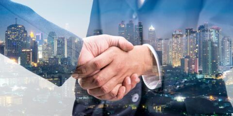 Shaking hands with background of a city