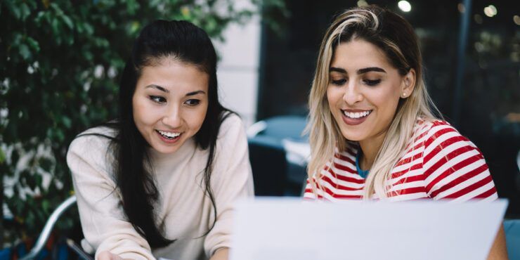 two female students studying a paper