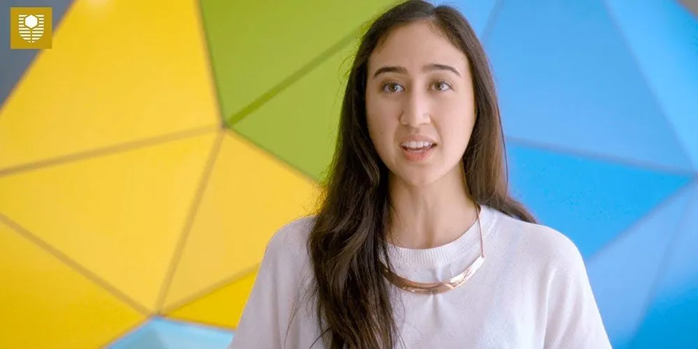 young female student in front of colourful background - play video