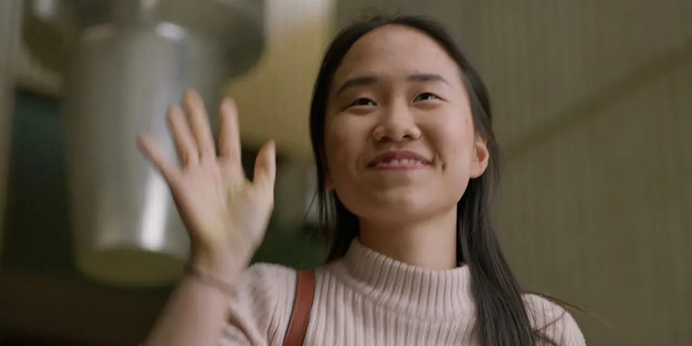 Young Asian student waving - play video