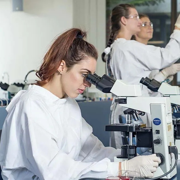 Health Sciences student, female, looking through microscope