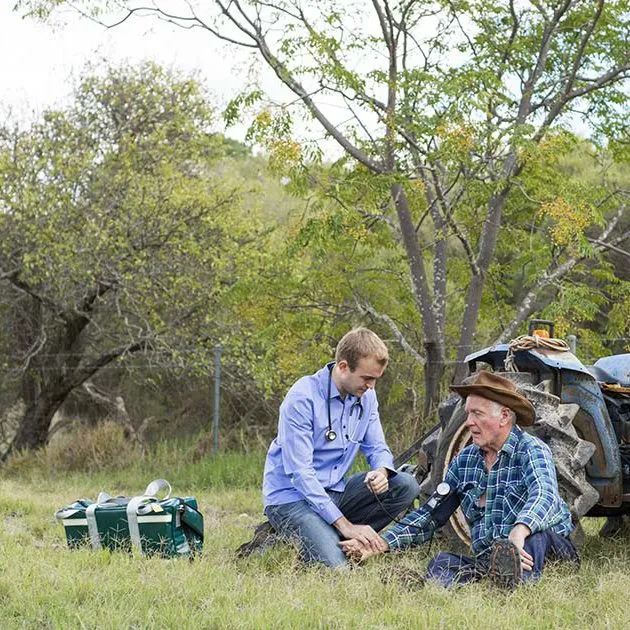 Medical student in a field helping injured man