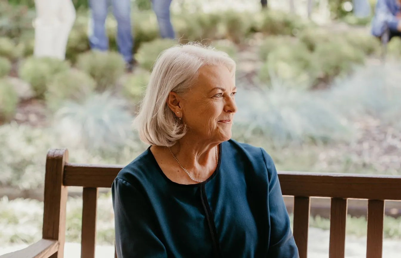 Alison Taylor sits on a bench, smiling off to the side