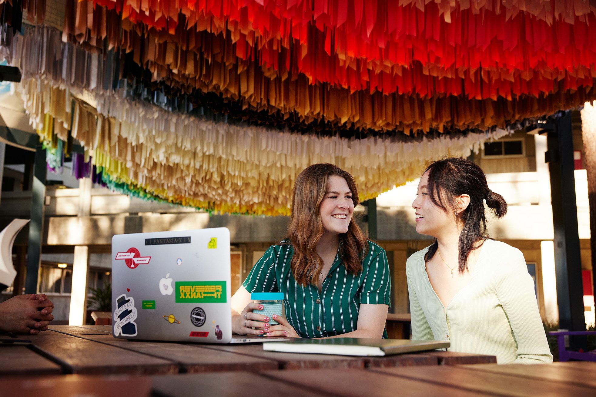 Two students sit on a table in the Creative Quarter