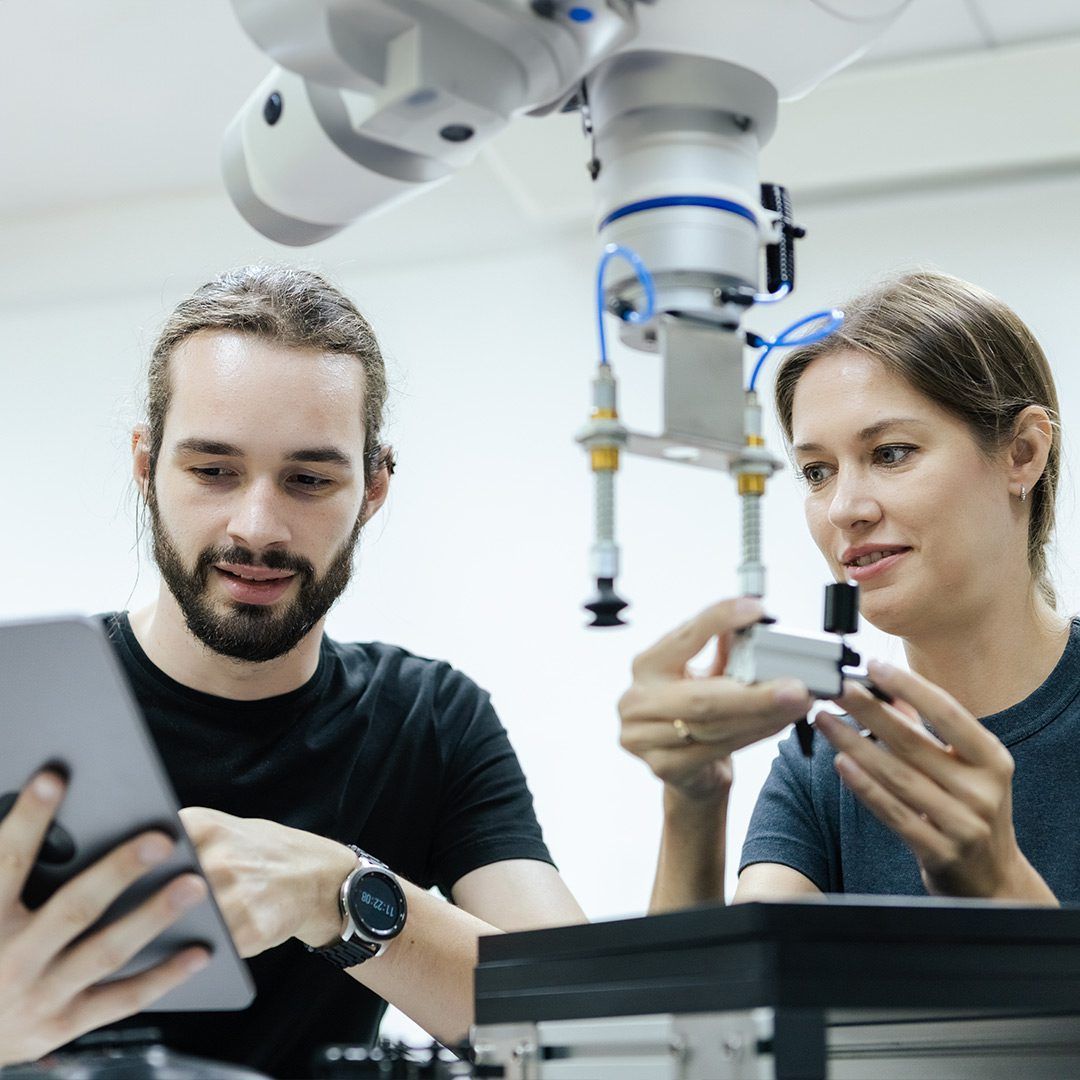 Two people interacting with a tablet, working on a project together.