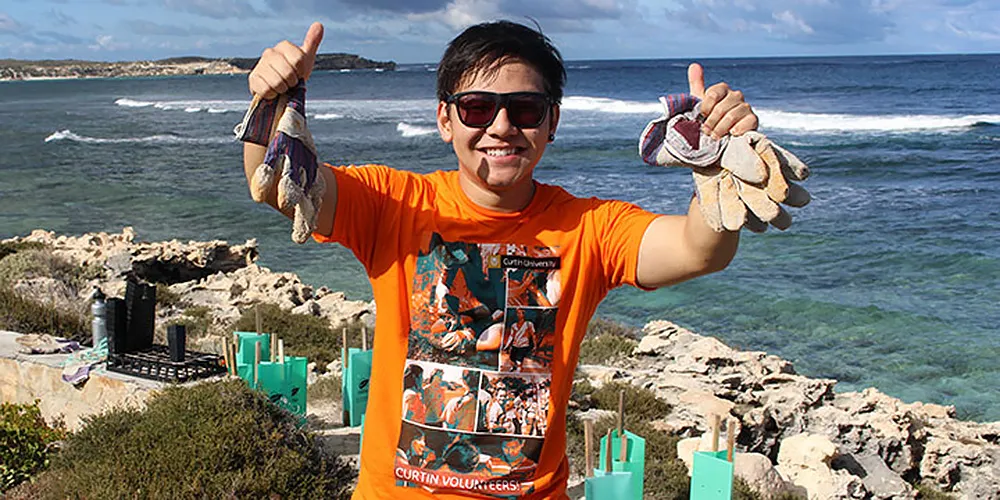 Curtin University volunteer volunteering at beachside cleanup