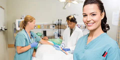 Portrait of nurse with digital tablet while doctor and colleague operating male patient in hospital