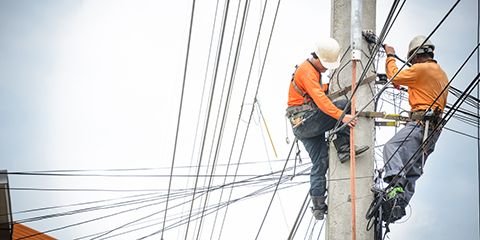 Two men fixing powerlines