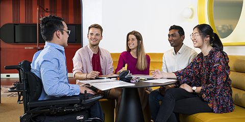 A group of people sitting around a table, talking