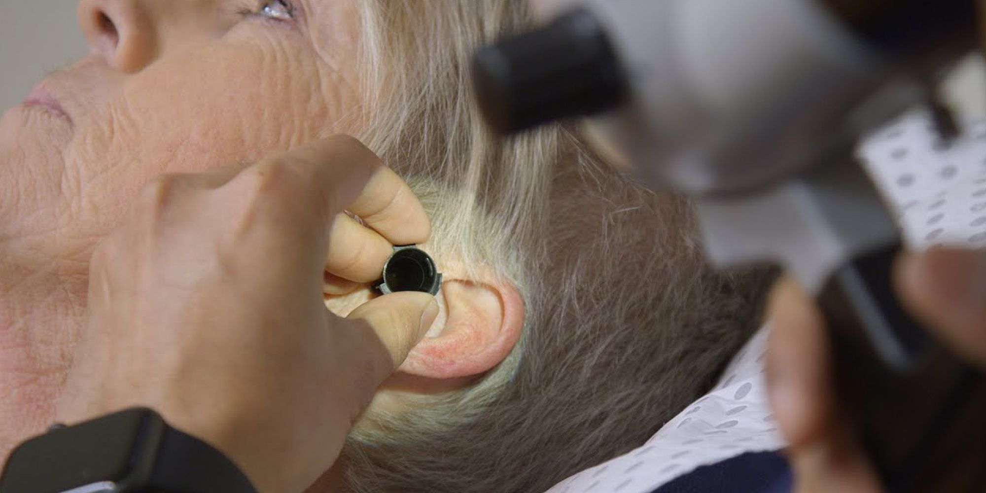 Older woman having her ear inspected - play video