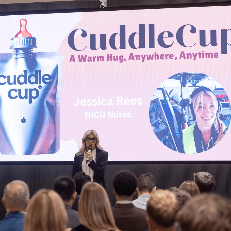 Founder of CuddleCup Jessica Rees presents her startup in front of a large screen