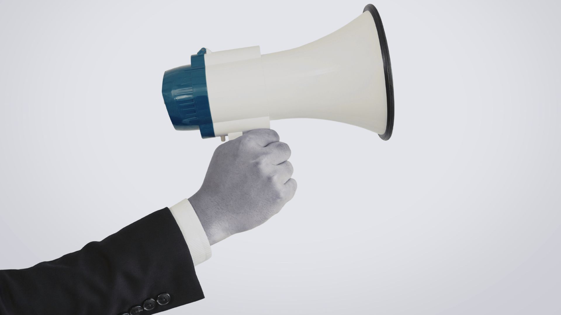 A person in a suit holding a megaphone, representing communication, promotion, or broadcasting a message.