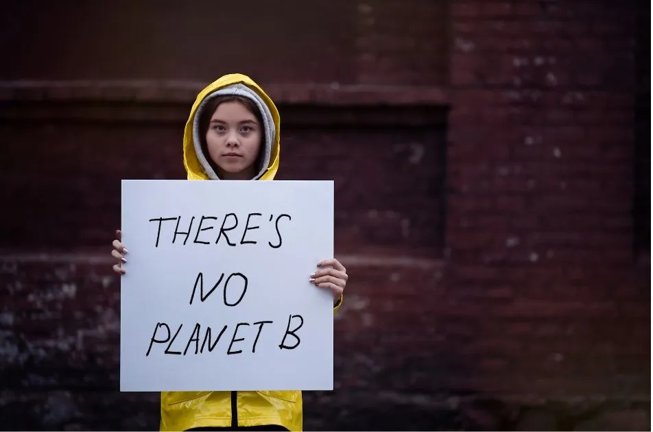 child holding sign about saving the planet