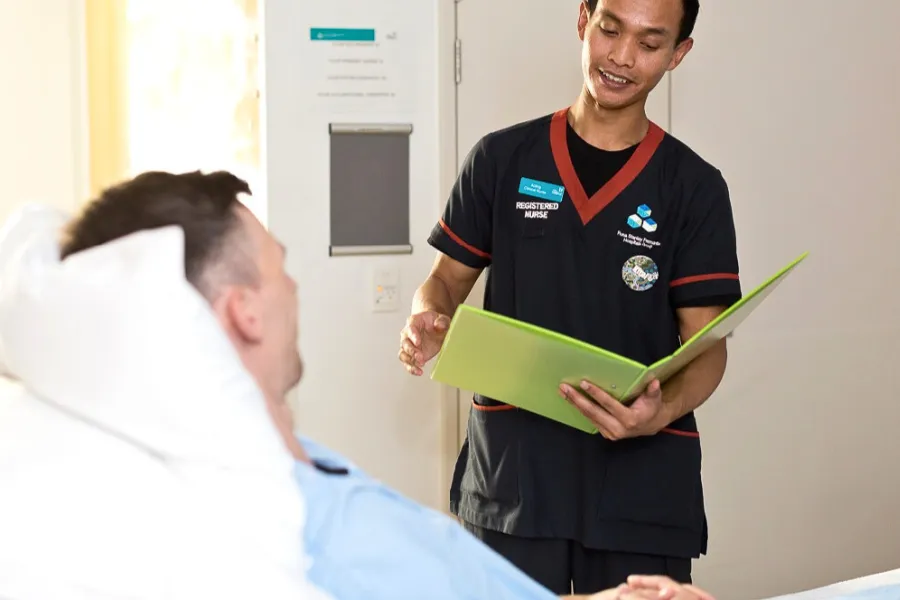 Khai standing next to a patient