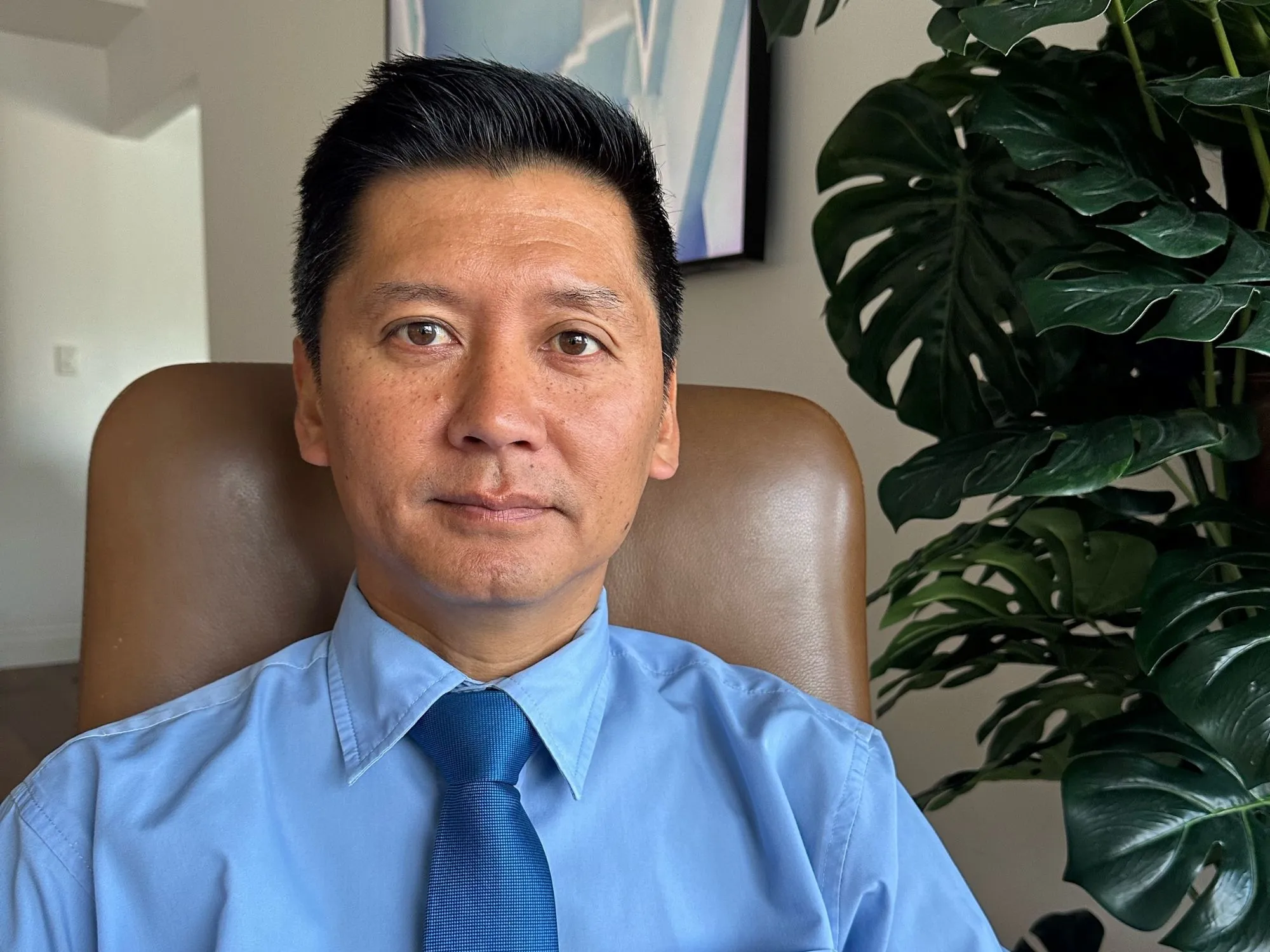 Curtin graduate Miles seated at desk