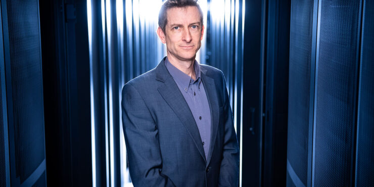 Man standing by a blue curtain