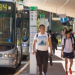 Students walking through a bus stop after getting off the bus