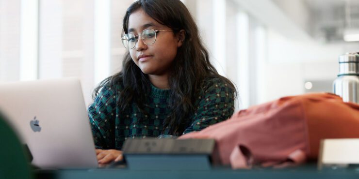 Student looking at a laptop while studying in TL Robertson Library.