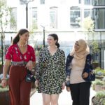 Three students walking on campus.