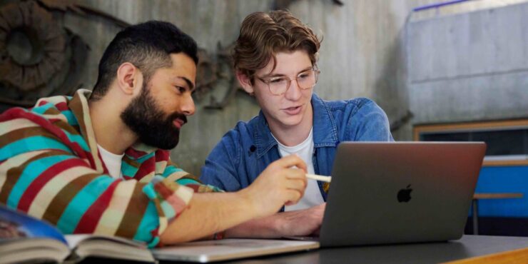 Two students looking at a laptop