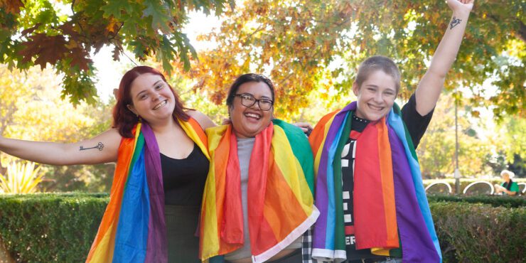 Three students with rainbow pride flags
