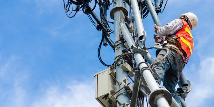 Technician working on high telecommunication tower.