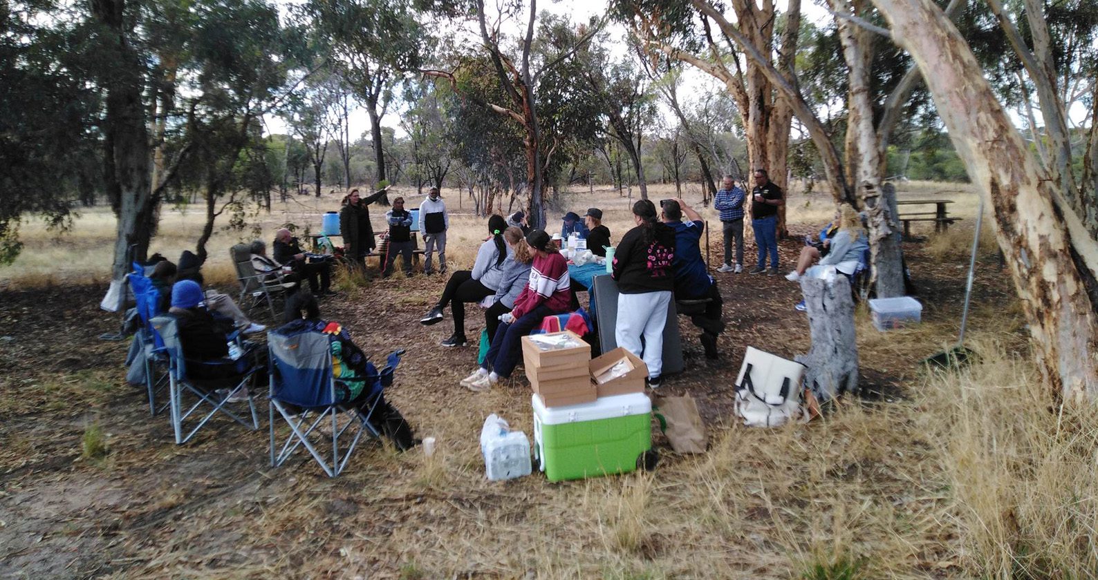 A group of students yarning under a tree.