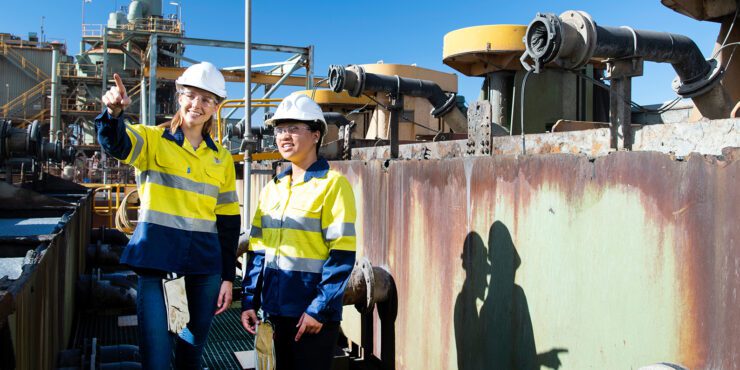 Two students wearing hi-visibility uniforms