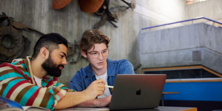 2-students-sitting-together-looking-at-a-laptop