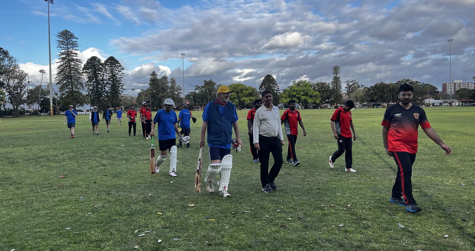 Science and Engineering students and staff walking onto the cricket pitch.