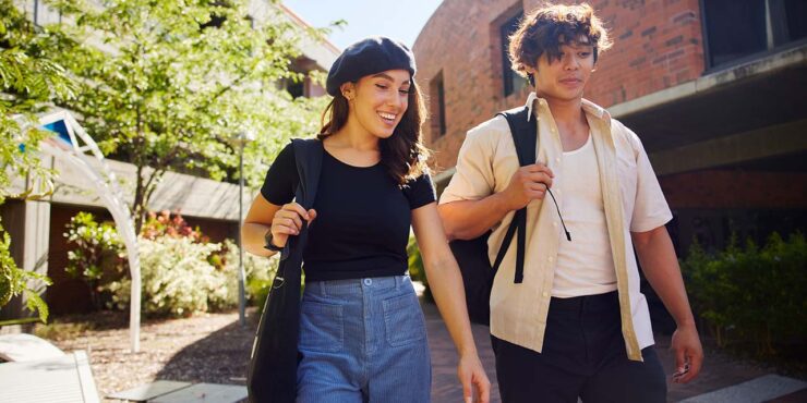 Male and female student walking through Bentley Campus