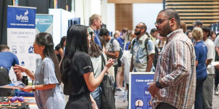 A male student speaking with an employer at a Careers Fair event