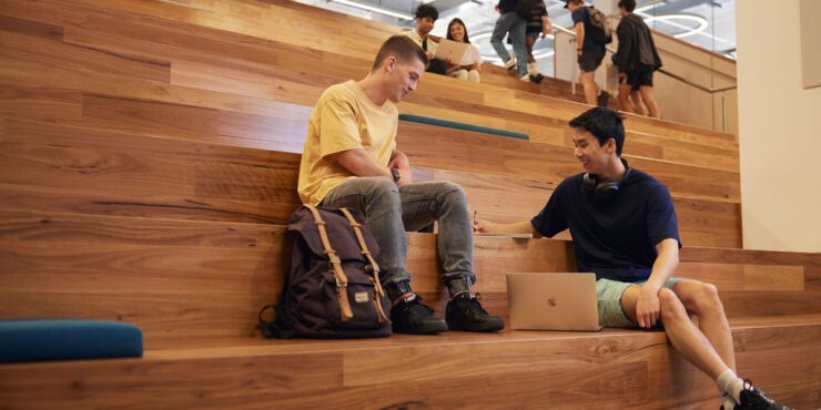 Students sitting on the TL Robertson Library stairs talking
