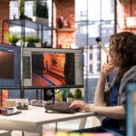 Woman works at computer on a space station video game environment.