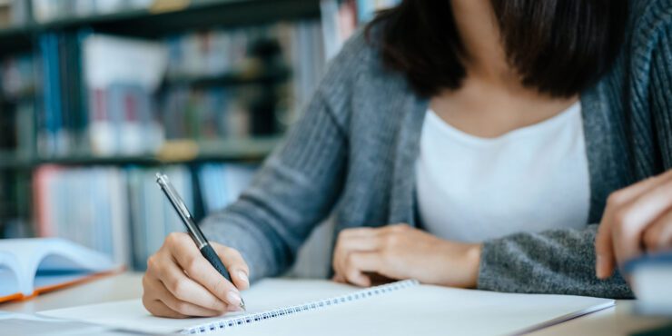 Student writing on a notepad.