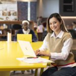 Woman on a laptop in a group study area