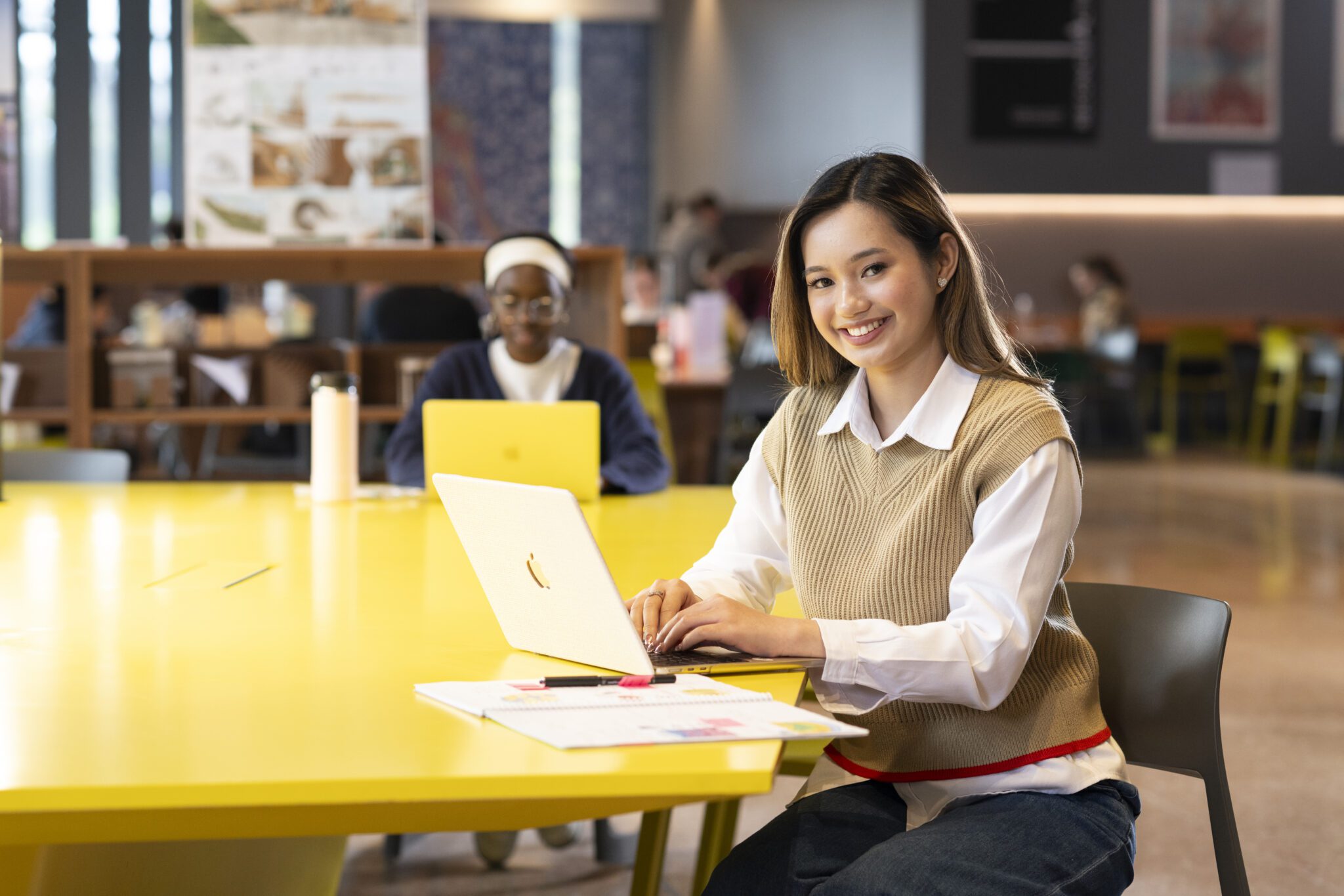 Woman on a laptop in a group study area