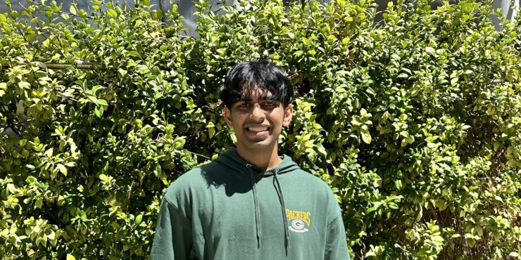 Rohan smiles at the camera whilst outdoors
